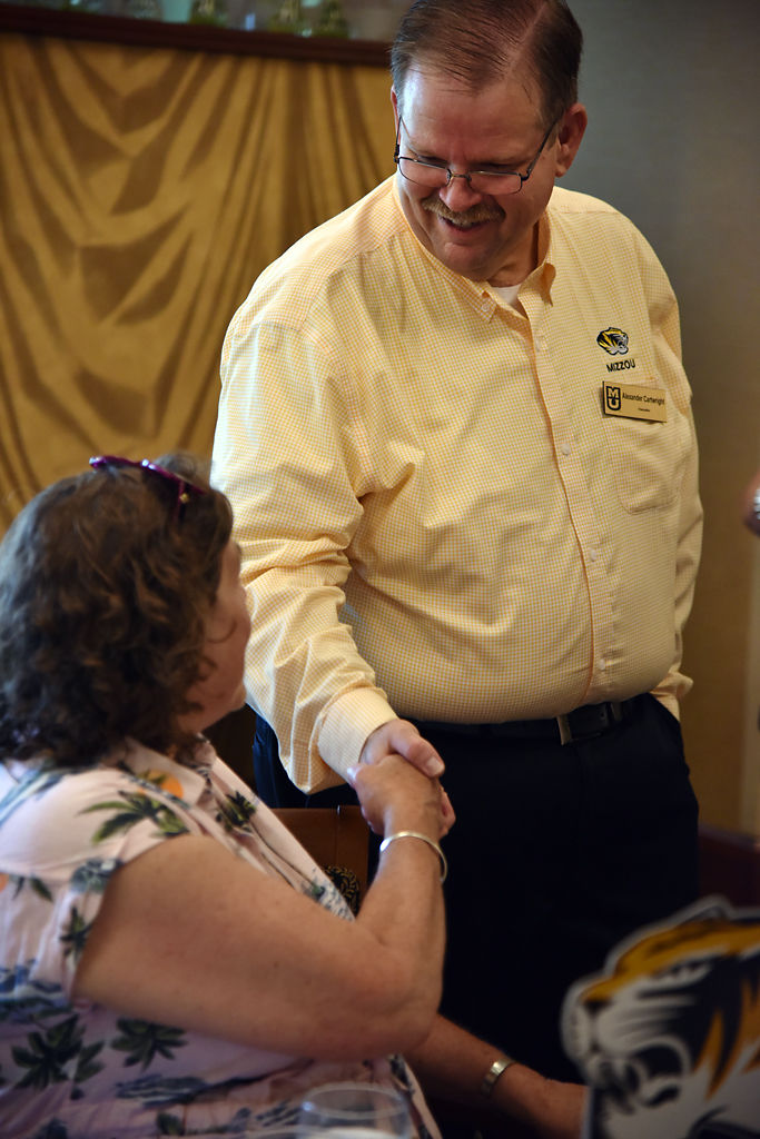Sally Macnamara, MU class of 1974, shakes hands with Chancellor Alexander Cartwright